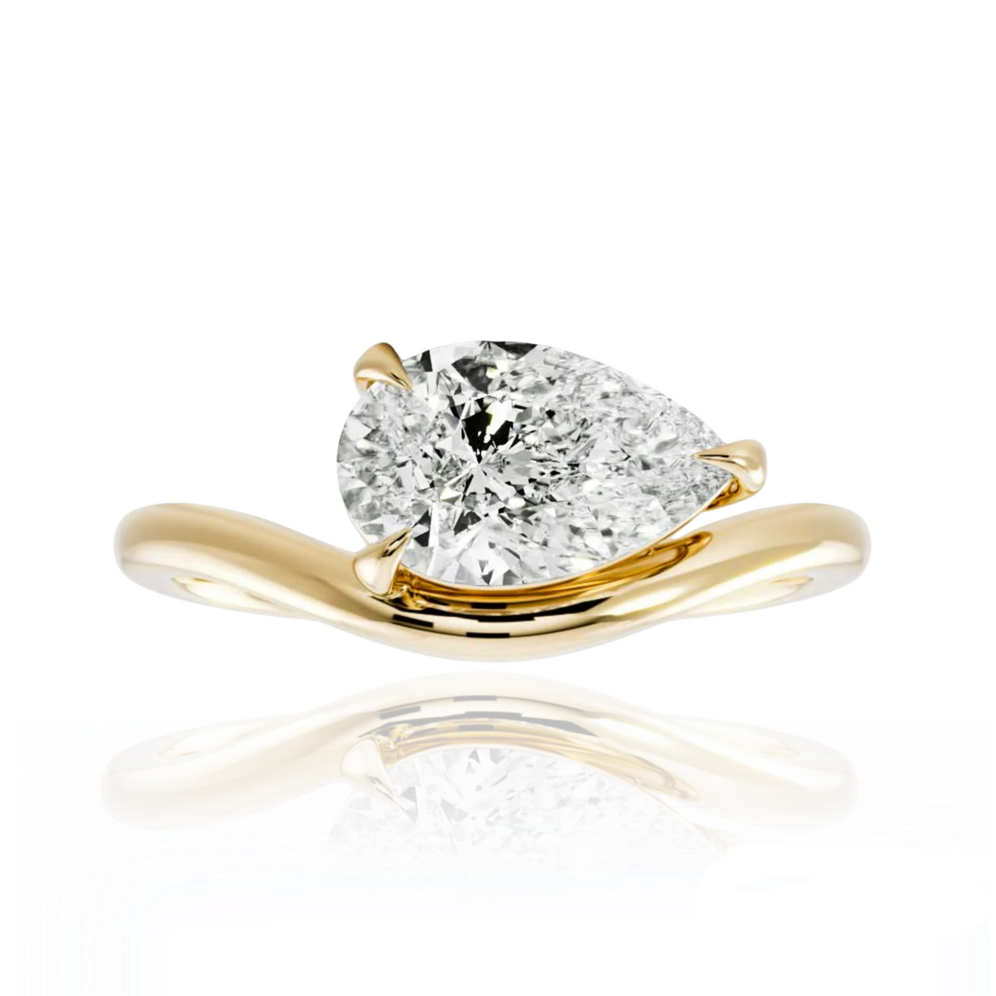 Gold ring with a pear-shaped diamond on a white background
