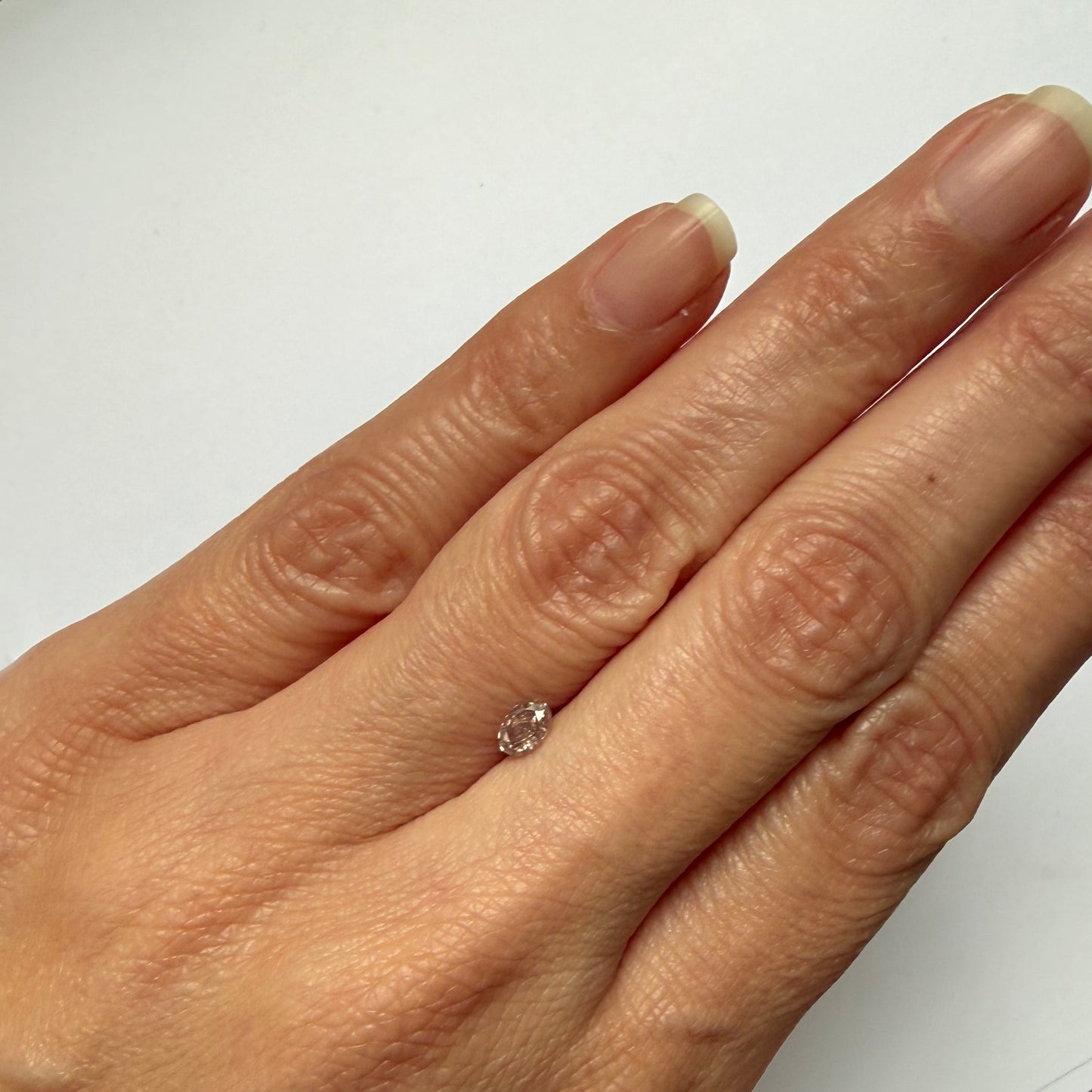 Hand wearing a diamond ring on a white background