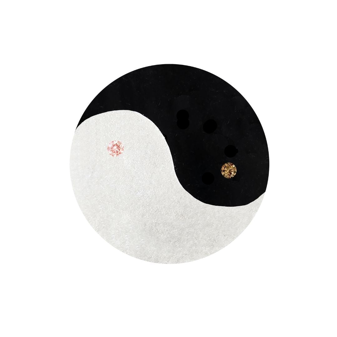 Black and white yin yang design with pink and gold gemstones on a white background. Argyle diamonds.